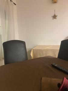 een tafel en een stoel met afstandsbediening bij Hotel Ana in Bran