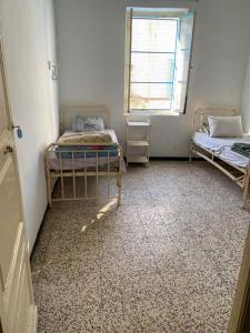 een kamer met twee bedden en een raam bij Hotel des Alliés in Tunis
