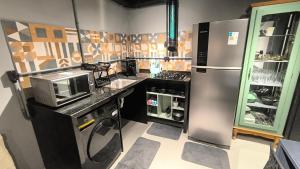 a kitchen with a stainless steel refrigerator and a counter at Studio de Praia in Matinhos