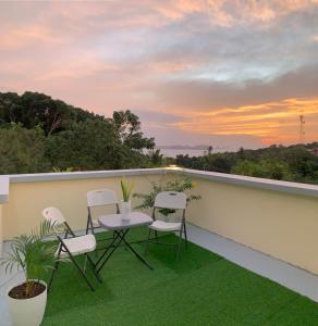a balcony with chairs and a table and a sunset at Mountain View Anilao in Mabini +27 photos