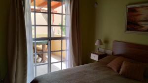 une chambre avec un lit et une grande fenêtre dans l'établissement Apartamento Confortable Samai Huasi, à Las Grutas