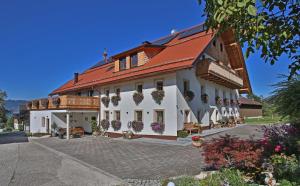 a large white building with a red roof at Bachbauer am Attersee in Weyregg