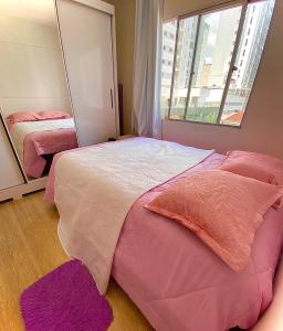 a bedroom with two beds and a mirror at Apartamento Loft in Balneário Camboriú