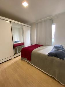 a bedroom with a large bed and a mirror at Apartamento Loft in Balneário Camboriú