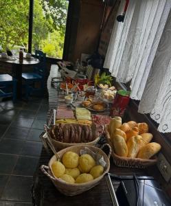 un tavolo con cesti di pane e altri prodotti alimentari di Encanto do Mar Praia do Rosa a Praia do Rosa