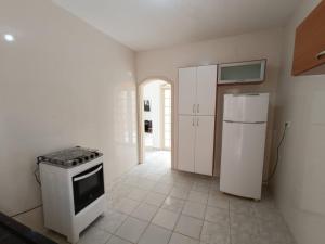 a kitchen with a stove and a refrigerator at Casa Duque Peruíbe in Peruíbe