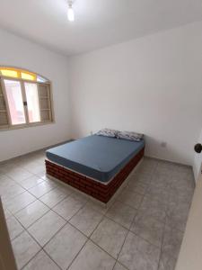 a bedroom with a bed in the corner of a room at Casa Duque Peruíbe in Peruíbe
