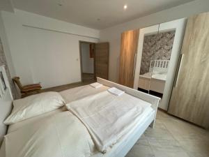 a bedroom with a white bed and a bathroom at City Lux Hannover in Hannover