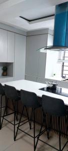 eine Küche mit einer weißen Theke und vier Stühlen in der Unterkunft Hillview Executive Self-Catering House in Blantyre