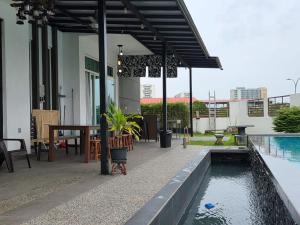 a patio with a table and a swimming pool at One Summerday in Desaru in Kangkar Chemaran