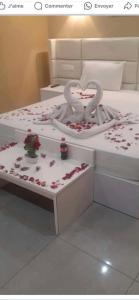 een wit bed met harten en rozen erop bij Hotel kssar in Oran