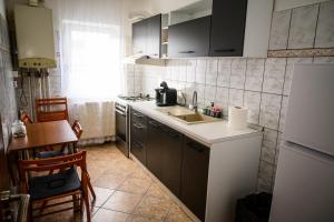 a small kitchen with a sink and a table at House Dey in Făgăraş