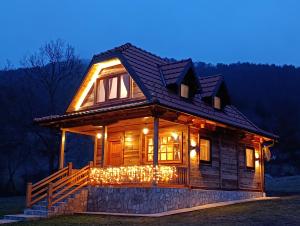 a log cabin lit up at night at Vila Sofija Mokra Gora in Mokra Gora