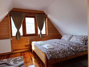 a bedroom with a bed and two windows at Vila Sofija Mokra Gora in Mokra Gora