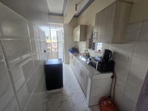 a small kitchen with a sink and a refrigerator at Flynn Stays in Bamburi