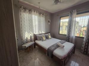 een kleine slaapkamer met een bed en een raam bij Flynn Stays in Bamburi
