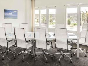 een vergaderruimte met een witte tafel en stoelen bij Ibis Yanbu in Yanbu +99 foto's