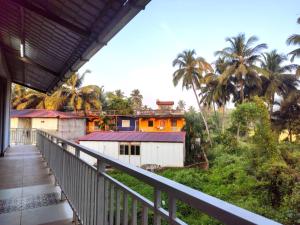 een balkon van een huis met palmbomen bij Eutopia Beach Resort in Morjim