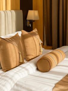 un letto con due cuscini e un asciugamano sopra di Atlantiis Suites Inn Mahmoorganj Near Vishwanath Temple a Varanasi