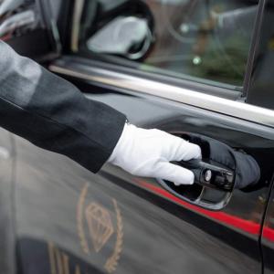 una mano in un guanto bianco che apre una porta di Atlantiis Suites Inn Mahmoorganj Near Vishwanath Temple a Varanasi