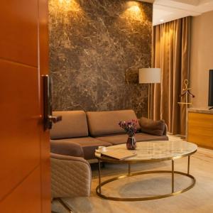 un soggiorno con un divano e un tavolo di Atlantiis Suites Inn Mahmoorganj Near Vishwanath Temple a Varanasi