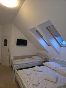 una stanza con due letti, una TV e lucernari di Biesiadny Dworek a Szpegawa