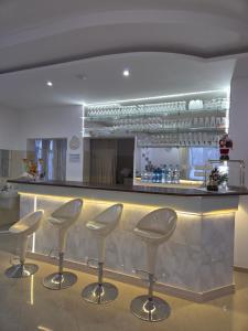 a bar with four stools in front of a counter at Biesiadny Dworek in Szpegawa