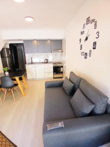 a living room with a couch and a clock on the wall at Departamentos Necochea Playa in Necochea +54 photos