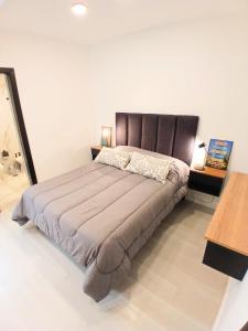 a bedroom with a large bed with a brown headboard at Departamentos Necochea Playa in Necochea