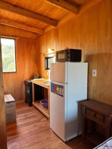 a kitchen with a white refrigerator and a microwave at La pinta roja in Punta Del Diablo