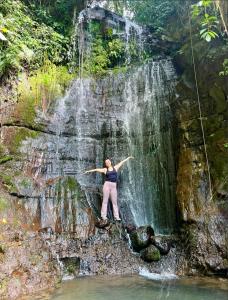 a woman standing in front of a waterfall at Sunset Farms and Waterfalls! in Tilarán +10 photos