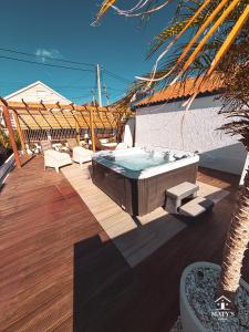 a hot tub on a deck with a palm tree at Maty's Place in Mafra