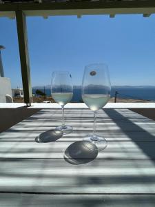 two glasses of white wine sitting on a table at Parostalkinghouse in Piso Livadi +30 photos