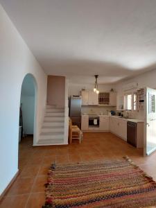 a kitchen with a staircase in the middle of a room at Parostalkinghouse in Piso Livadi