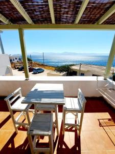 a table and chairs on a balcony with a view of the ocean at Parostalkinghouse in Piso Livadi