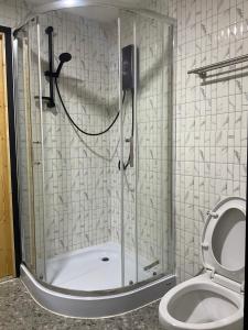 een douche met een glazen deur naast een toilet bij Mae on country home in Ban On Luai