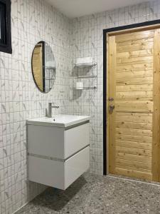 een badkamer met een witte wastafel en een spiegel bij Mae on country home in Ban On Luai