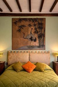 a bedroom with a bed with a painting on the wall at Vita Toscana Guest House in Chiusi +8 photos