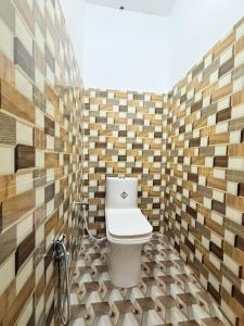 a bathroom with a toilet in a room with wooden tiles at Hotel embrace in Bhauli