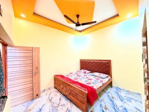 a bedroom with a bed and a ceiling fan at Hotel embrace in Bhauli