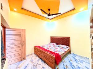 a bedroom with a bed and a ceiling fan at Hotel embrace in Bhauli