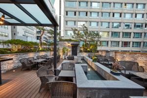 a patio with tables and chairs and a building at Hotel Soulhada Gangnam in Seoul