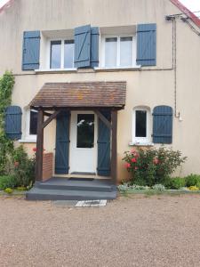 a house with a white door and a porch at LA Chataigne in Santranges