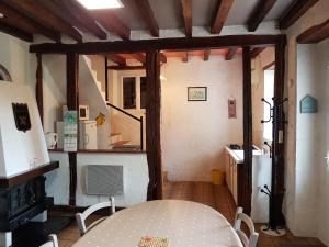 een eetkamer met een tafel en een koelkast bij LA Chataigne in Santranges