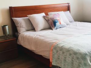 a bed with a wooden headboard and pillows at Lucas Apart 2Bdr & 2Bth with pool in Mār Yūsuf +18 photos