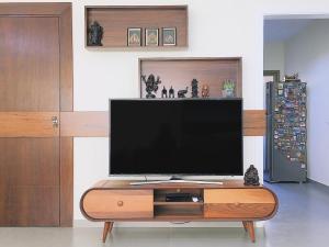 a flat screen tv sitting on top of a wooden entertainment center at Lucas Apart 2Bdr & 2Bth with pool in Mār Yūsuf