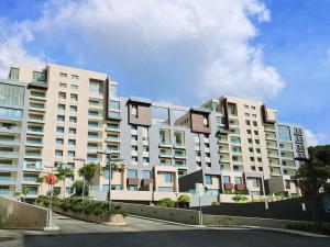 a large white apartment building with a parking lot at Lucas Apart 2Bdr & 2Bth with pool in Mār Yūsuf