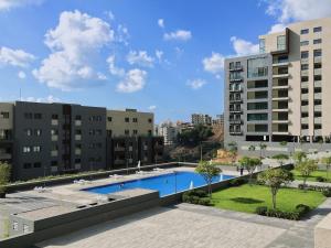 an apartment complex with a swimming pool and buildings at Lucas Apart 2Bdr & 2Bth with pool in Mār Yūsuf