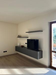 a living room with a flat screen tv on a wall at Casa L'Oliver in Limone sul Garda