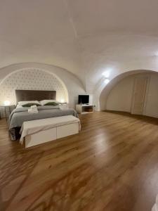 een grote slaapkamer met een bed en een houten vloer bij VagaLuna Short Stay in Catania